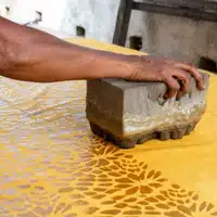 Global Mamas Batiking Workshop stamping wax design onto fabric