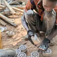 Bead Making Workshop at Global Mamas removing fired recycled glass beads from the mold