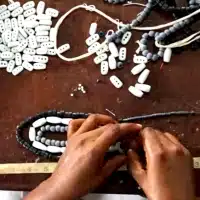 Global Mamas Beading Workshop at the Global Mamas Fair Trade Zone assembling a fair trade necklace