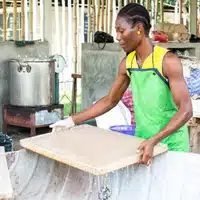Pulling a sheet of paper through the trough during a Papermaking Workshop at the FTZ